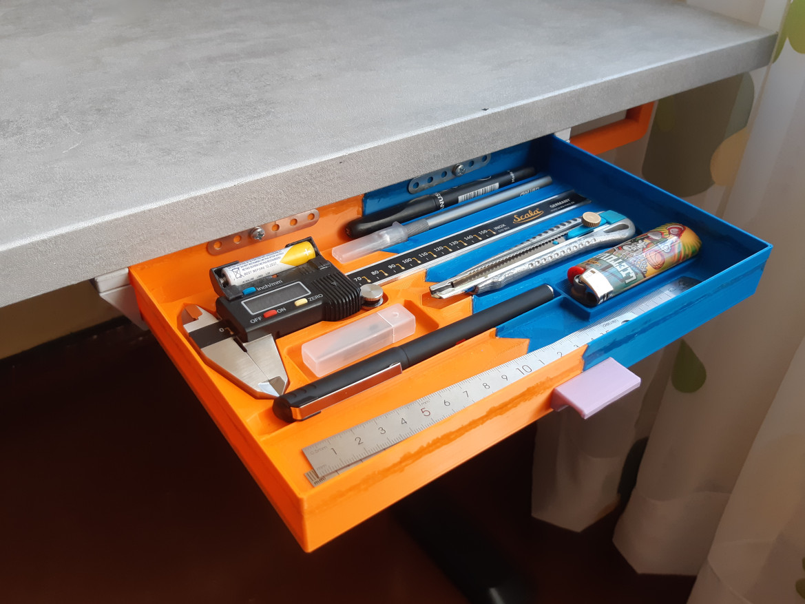 Prie stalo pritvirtintas stalčiukas su įrankiais.