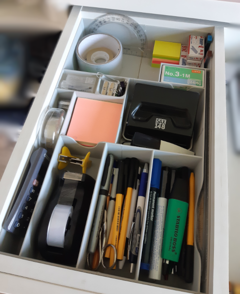 Reali 3D spausdinta dėžutė su skyreliais ir kanceliarinėmis priemonėmis juose.