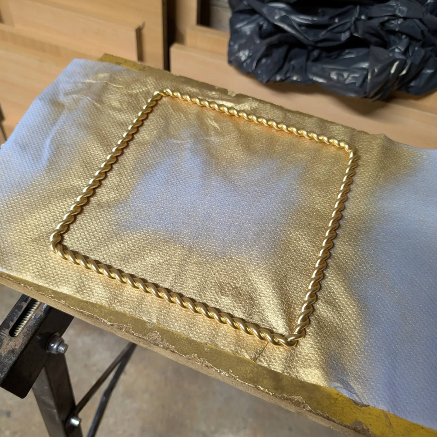 Auksiniais dažais nupurkštas rėmelis.