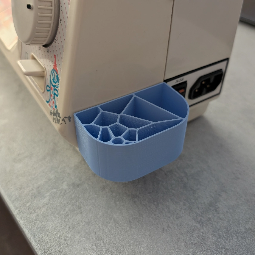 Reali Voronoi pieštukinė priklijuota prie siuvimo mašinos šono.