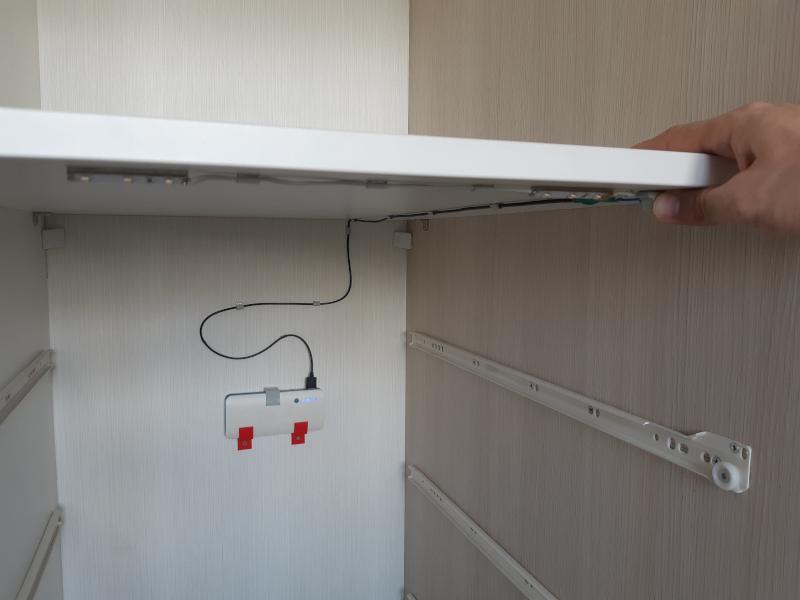 Stalčių komoda su išjungtomis LED juostelėmis ir nuspaustu mygtuku.