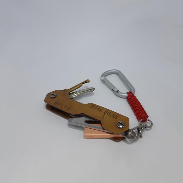 Varinis S formos raktų laikiklis su išstumtais raktais.