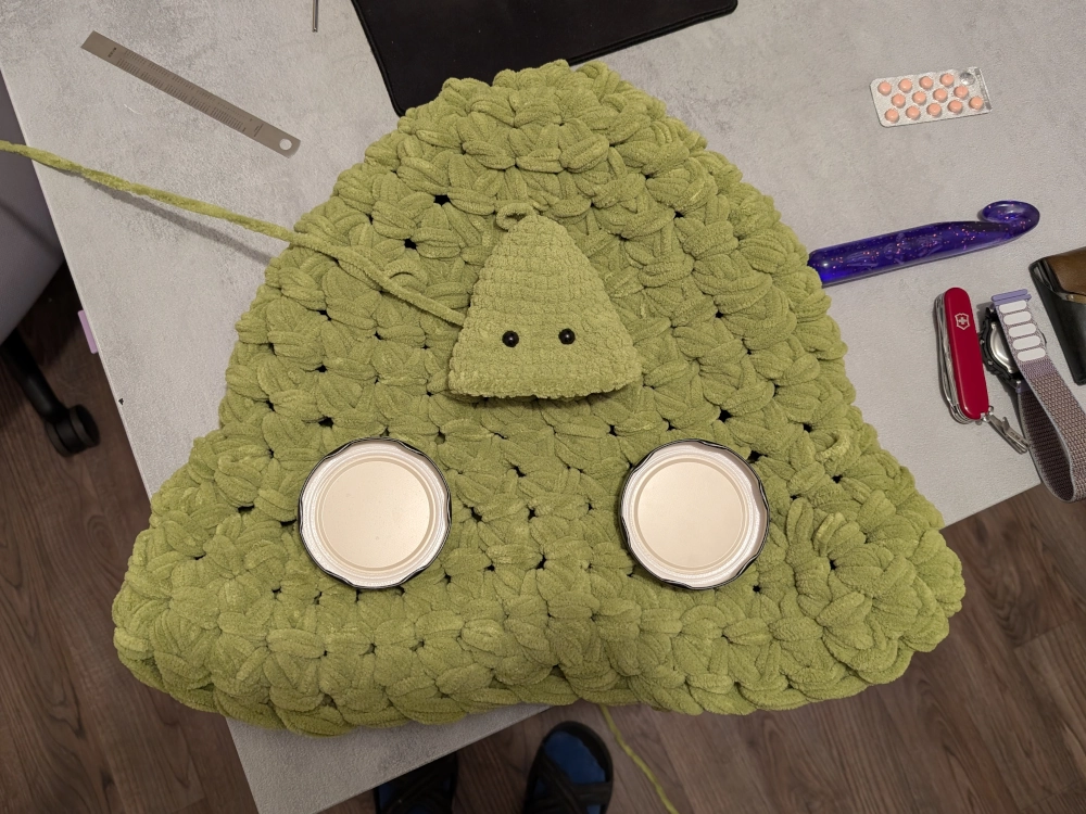 Pusė didžiojo Grinčiuko galvos su stiklainių dangteliais vietoje akių.