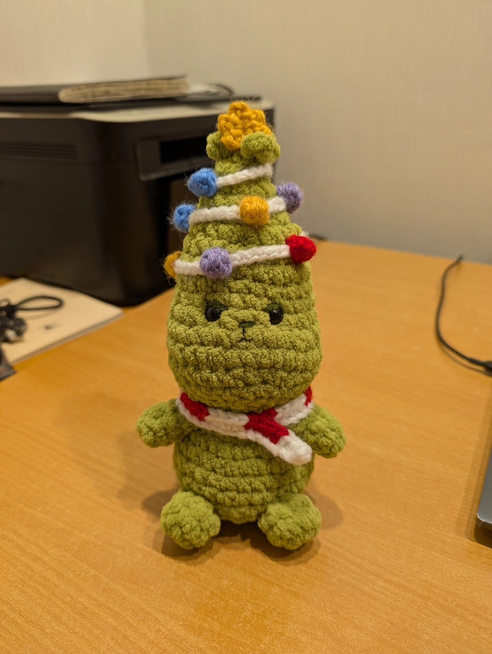 Ant stalo sėdintis nertas pliušinis Grinčiukas.